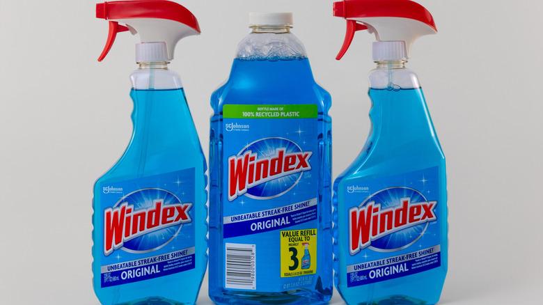 two Windex spray bottles and one refill bottle against a white background