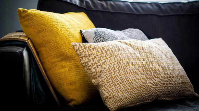 yellow accent pillows on black couch