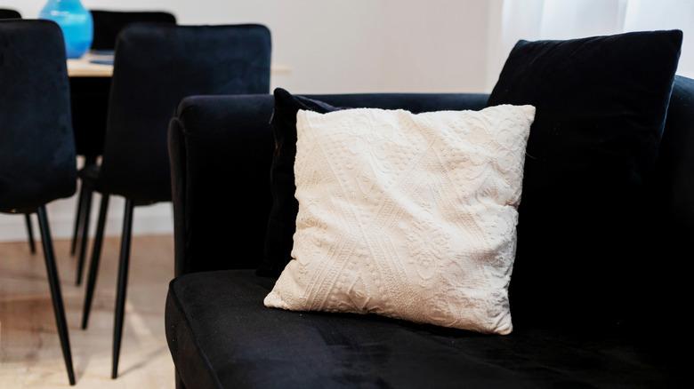 close up of black couch with white pillow