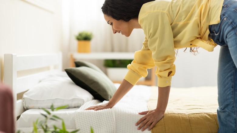 Woman smoothing sheets happily