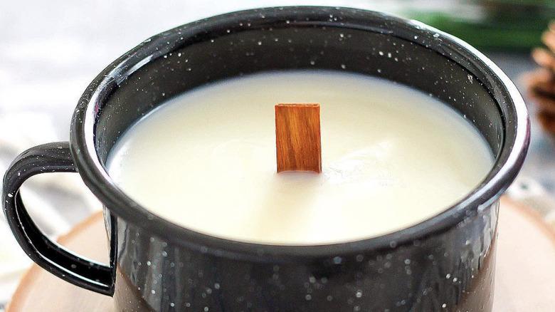 Homemade wood wick candle in enamel coffee mug