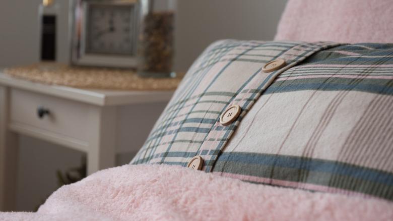 Pillow with buttons on a bed