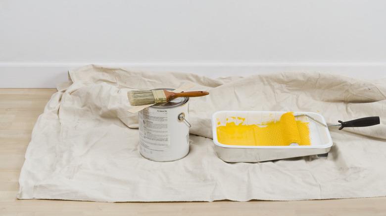 Paint can and supplies on drop cloth