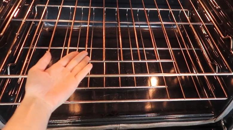 Woman's hand indicating oven racks