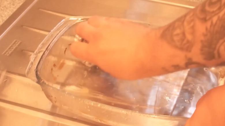 Scrubbing out casserole dish with ball of aluminum foil