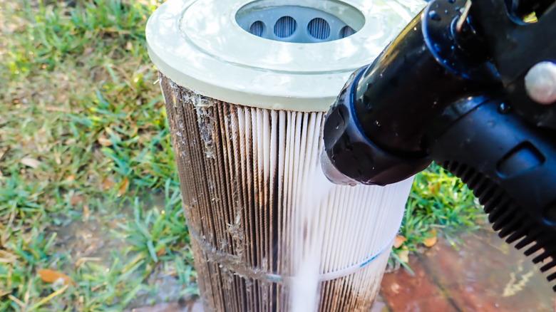 spraying dirty pool filter