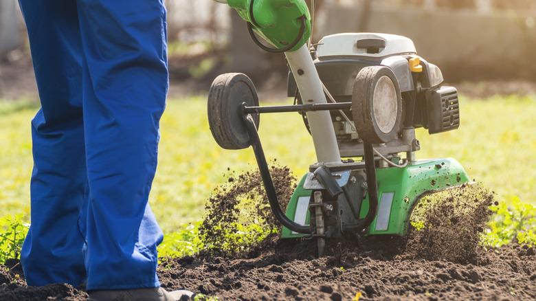 Person using a tiller in garden