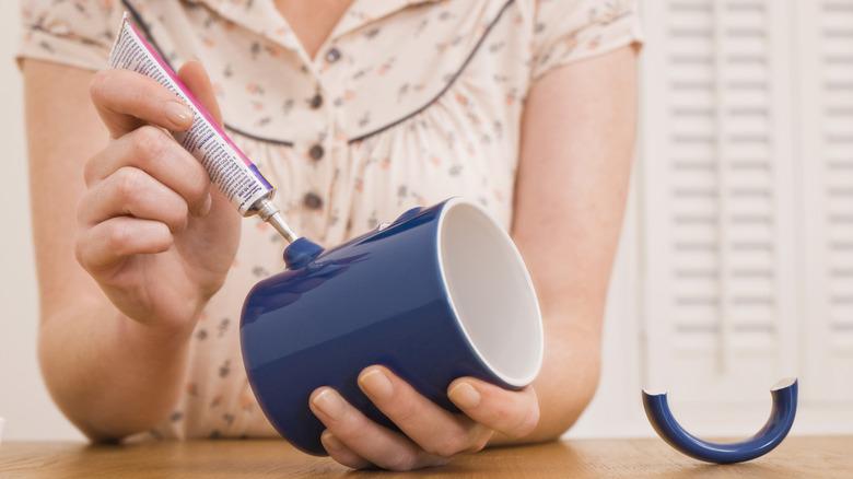 Woman gluing a handle on a blue mug