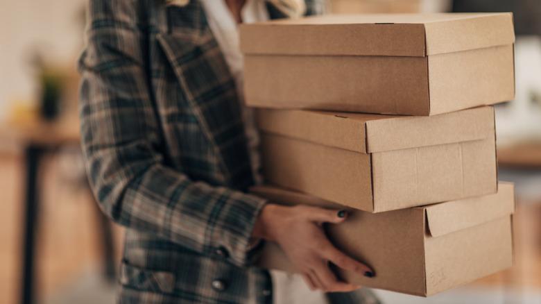 Woman holding brown cardboard shoeboxes