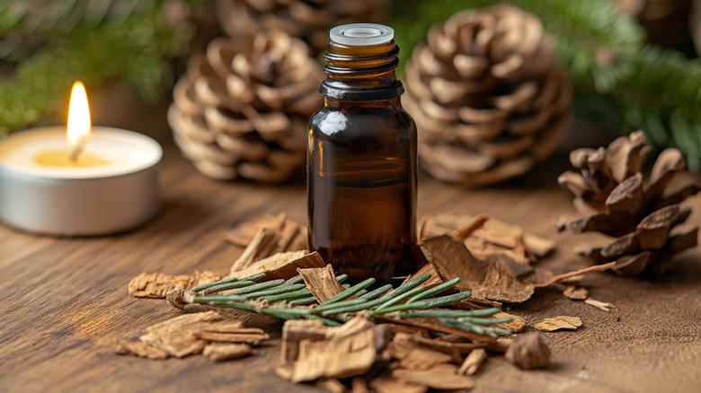a bottle of cedarwood essential oil surrounded by cedar chips