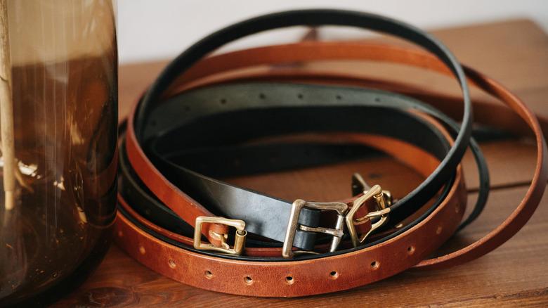 Empty glass jar and belts on table