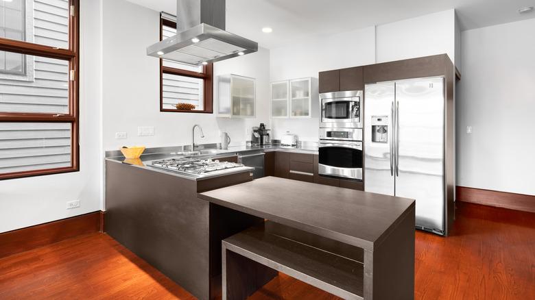 modern kitchen with orange-toned outdated wood floors