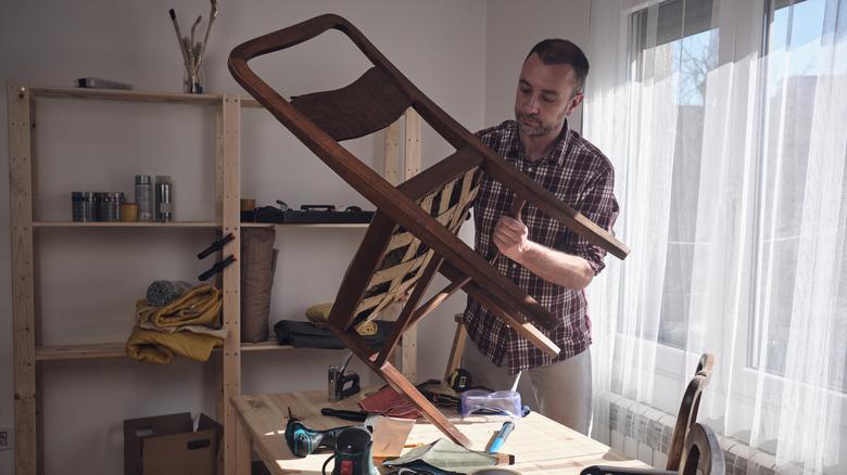 person redoing chair on workbench