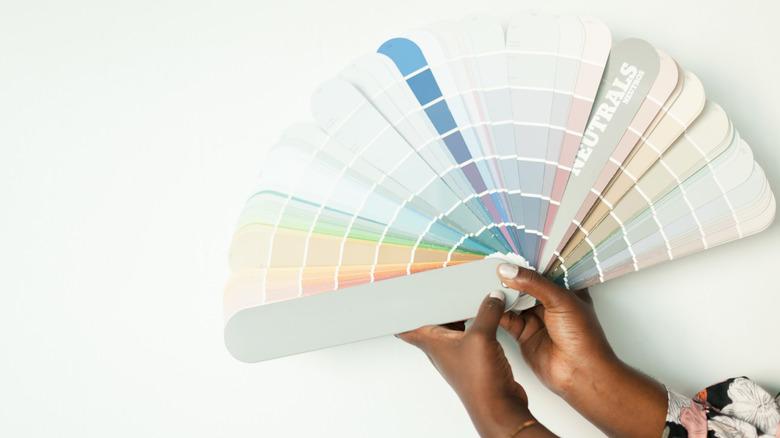woman fanning out a paint sample deck