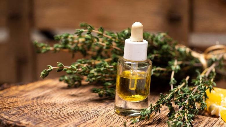 thyme sprigs and thyme oil in a bottle