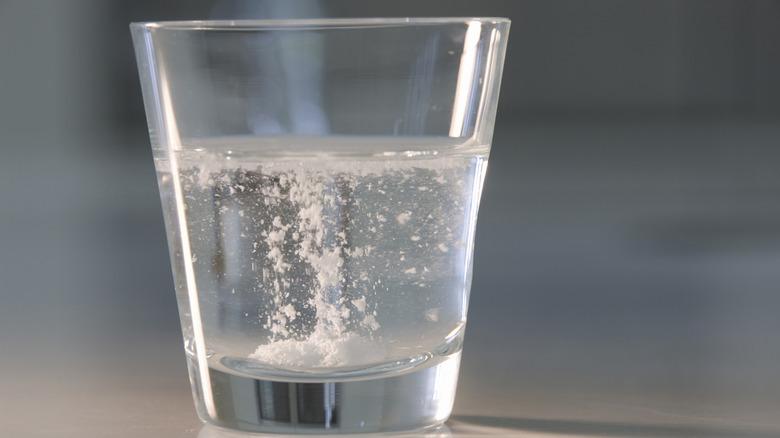Alka-Seltzer fizzing in a glass of water