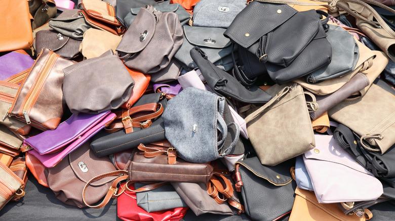 handbags laying in a messy pile