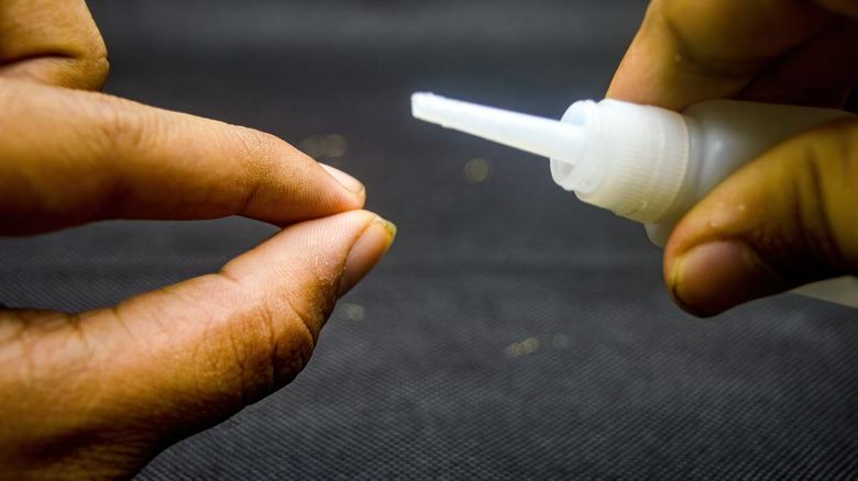 Person holding super glue bottle