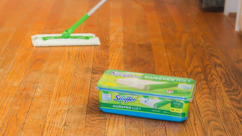 Swiffering a hardwood floor with box of pads