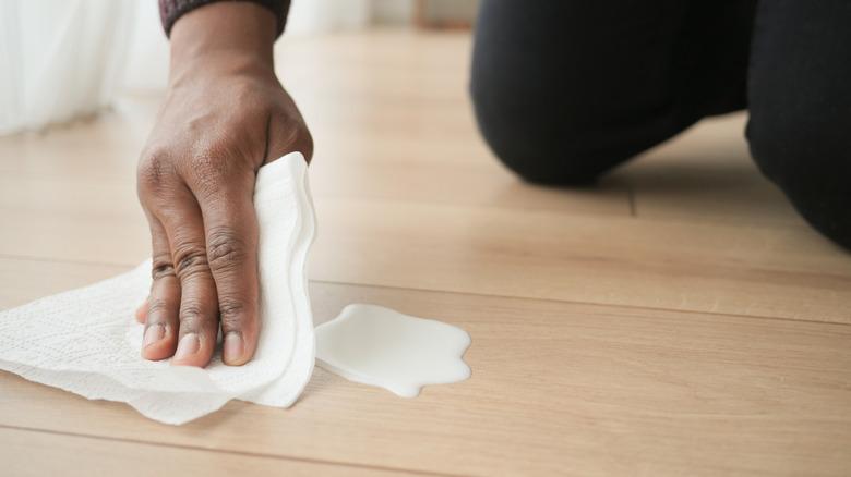 Man drying spilled milk on floors