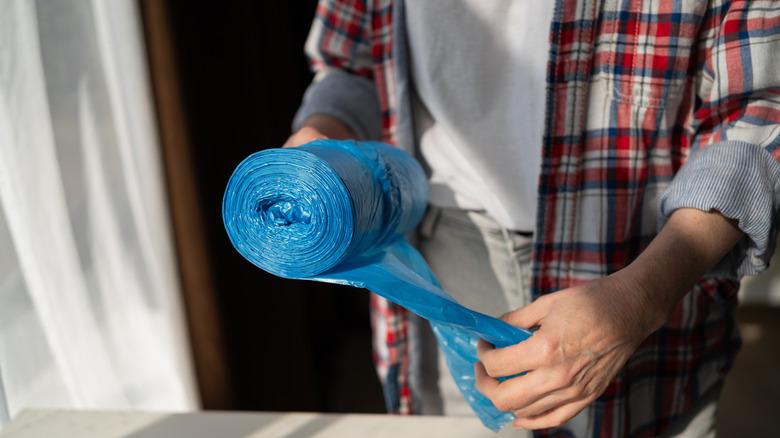 Woman holding roll of trash bags