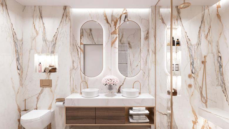 marble-looking tiles in a renovated bathroom with white and gold color scheme