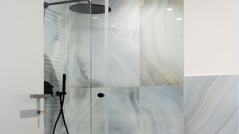 matte black showerhead in porcelain slab shower
