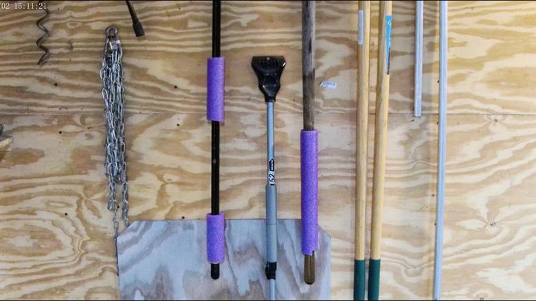 purple pool noodles on handles of yard tools
