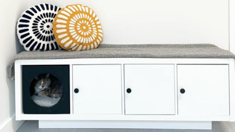 IKEA KALLX bench shown with three doors, two of which are hiding a litter box, and one open cubby with an occupied  cat house