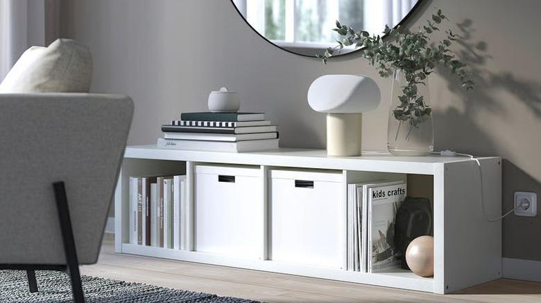 IKEA KALLAX four cube shelf in living room with books and bins