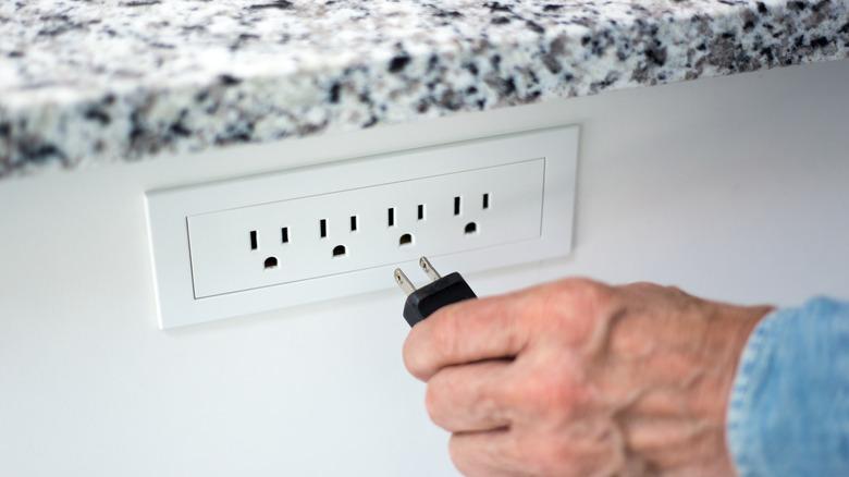 The moment before plugging an electrical device into a receptacle