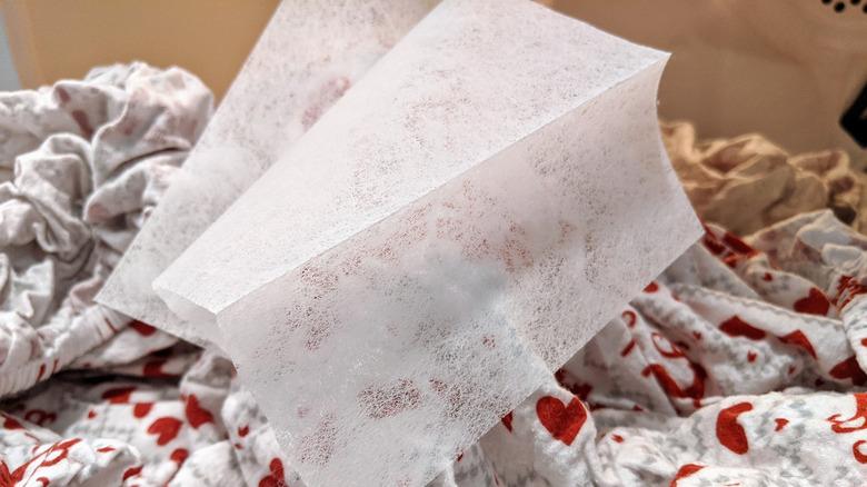 Dryer sheet on pile of blankets and sheets