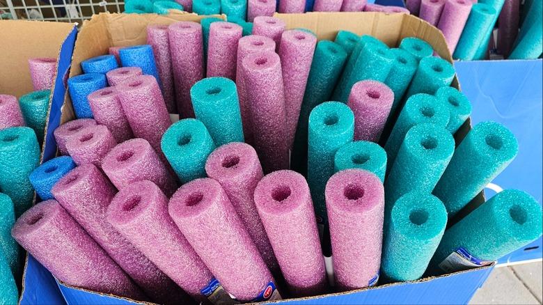 pink blue and turquoise pool noodles in shop display